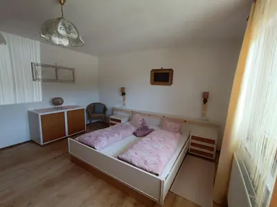 a bedroom with a bed with a teddy bear on it at Ferienwohnung Marchnerhof in Terento