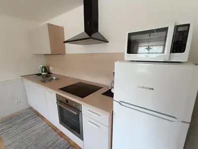 a white kitchen with a microwave and a refrigerator at Ferienwohnung Marchnerhof in Terento