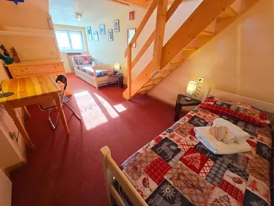 a bedroom with a bed with a quilt on it at Le Vette di Moena - Alpine Stay Apartments in Moena