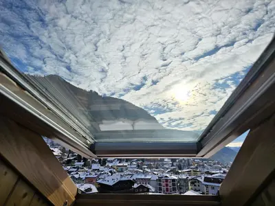 an open window with a view of a city at Le Vette di Moena - Alpine Stay Apartments in Moena