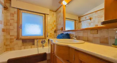 a bathroom with a sink and a bath tub at Homeby, Casa Due Vette in Cortina dʼAmpezzo