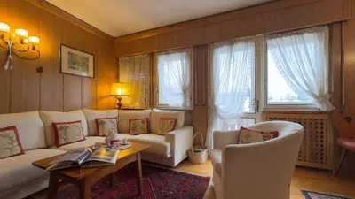 a living room with a white couch and a table at Homeby, Casa Due Vette in Cortina dʼAmpezzo