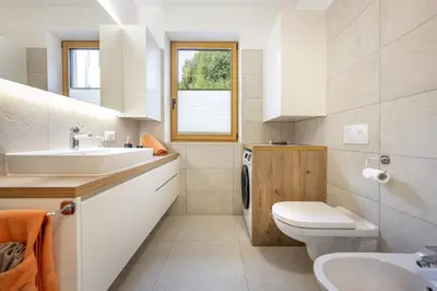 a white bathroom with a sink and a toilet at Apartments No 10 in Ponte Gardena