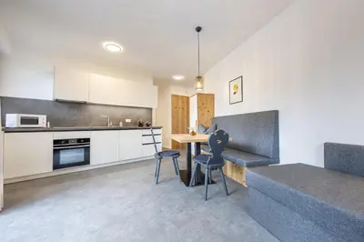 a kitchen and living room with a table and chairs at Apartments No 10 in Ponte Gardena