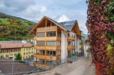 a large wooden house with a solar roof at Apartments No 10 in Ponte Gardena