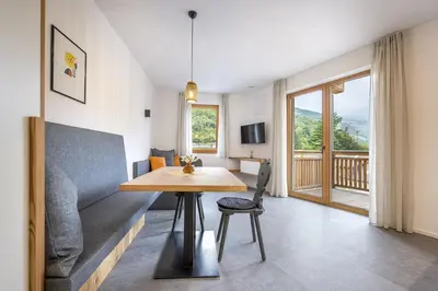 a living room with a table and a couch at Apartments No 10 in Ponte Gardena