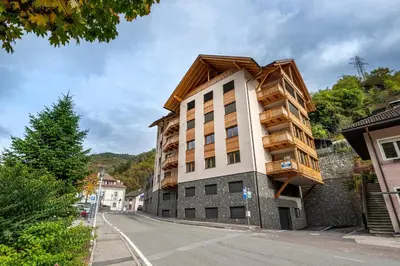 a building with a wooden roof on a street at Apartments No 10 in Ponte Gardena