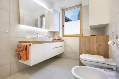 a bathroom with a sink and a toilet and a window at Apartments No 10 in Ponte Gardena