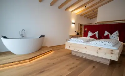 a bathroom with a tub and a bed and a bath tub at Lanzenschuster in San Genesio Atesino