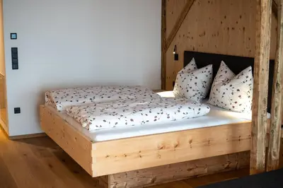 a bedroom with a wooden bed with pillows at Lanzenschuster in San Genesio Atesino
