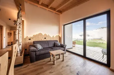 a living room with a couch and a flat screen tv at Stabingerhof Chalets & Apartment-Farm stay in Bressanone