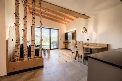 a kitchen and dining room with a desk and a dining table at Stabingerhof Chalets & Apartment-Farm stay in Bressanone
