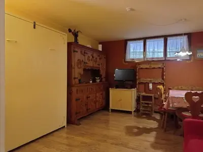 a living room with a table and a television at Licia in Canazei