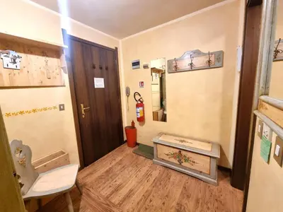 a hallway with a door and a table in a room at Licia in Canazei
