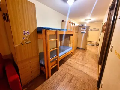 a small room with a bunk bed with a ladder at Licia in Canazei