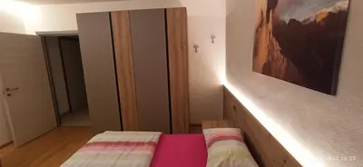 a room with a bed and a painting on the wall at Casa Brugnara in Pozza di Fassa