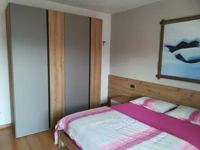 a bedroom with a bed and a mirror on the wall at Casa Brugnara in Pozza di Fassa