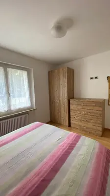 a bedroom with a large bed and wooden cabinets at Casa Brugnara in Pozza di Fassa