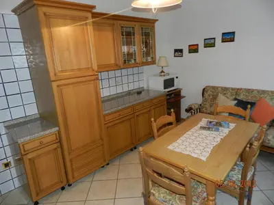 a kitchen with a wooden table and a dining room at Casa Brugnara in Pozza di Fassa