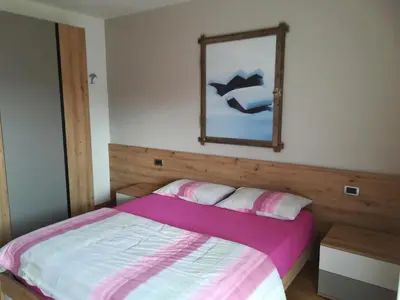 a bedroom with a bed with a mirror on the wall at Casa Brugnara in Pozza di Fassa