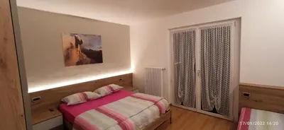 a bedroom with a bed and a window at Casa Brugnara in Pozza di Fassa