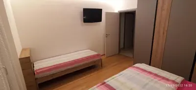 a small room with a bed and a tv on the wall at Casa Brugnara in Pozza di Fassa