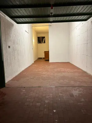 an empty room with a brick floor and white walls at Appartamento Dolomiti in Castello di Fiemme