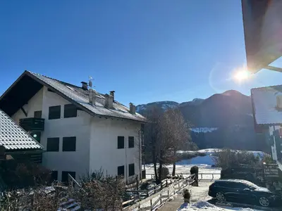 a house with a car parked in front of it at Appartamento Dolomiti in Castello di Fiemme
