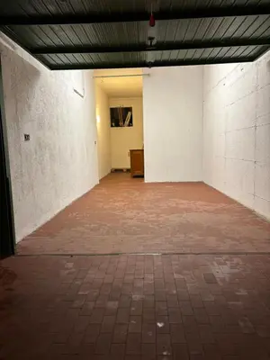 an empty room with a brick floor and white walls at Appartamento Dolomiti in Castello di Fiemme