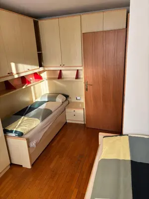 a small bedroom with a bed and a closet at Appartamento Dolomiti in Castello di Fiemme