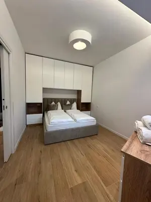 a bedroom with a bed with white sheets and a window at Villa Hajdi Q & U in Merano