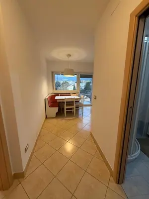 a kitchen with white cabinets and a sink and a refrigerator at Vista Rosengarten in Bolzano
