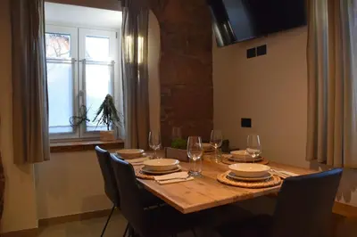 a dining room table with chairs and a window at La casa dela Nona in Cavalese