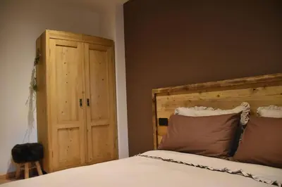 a bedroom with a bed and a wooden door at La casa dela Nona in Cavalese