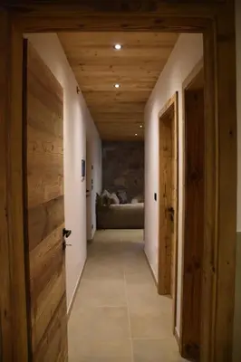 a hallway with wooden doors and a couch in a room at La casa dela Nona in Cavalese