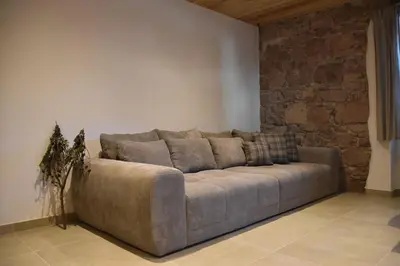 a large couch in a room with a brick wall at La casa dela Nona in Cavalese
