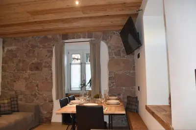 a dining room with a table with chairs and a couch at La casa dela Nona in Cavalese