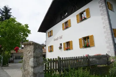 a white building with windows and a wooden fence at Kampflhof Apartments in Schenna