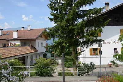 a white building with a tree in front of it at Kampflhof Apartments in Schenna