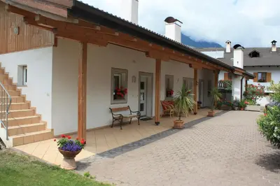 a patio of a house with a bench on it at Kampflhof Apartments in Schenna