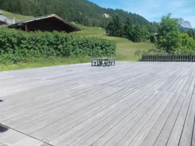 a building with a tree in front of it at Casa Al Mesdì in Pozza di Fassa