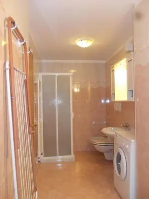 a bathroom with a sink and a washing machine at Casa Al Mesdì in Pozza di Fassa