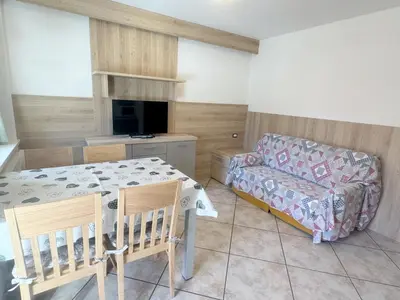 a white kitchen with white cabinets and a sink at Casa Al Mesdì in Pozza di Fassa