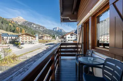 a balcony with a table and chairs and mountains at Cesa de Paio in Mazzin