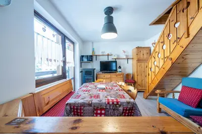 a living room with a bed and a staircase at Cesa de Paio in Mazzin