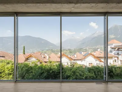 an empty room with a view of houses and mountains at Villa Alvarium in Schenna