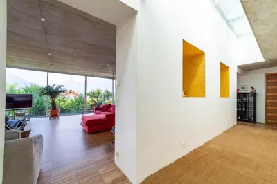 a living room with a red couch and a large window at Villa Alvarium in Schenna