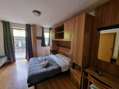 a bedroom with a bed with a teddy bear on it at TEA San Pellegrino - DOLOMITI in Falcade