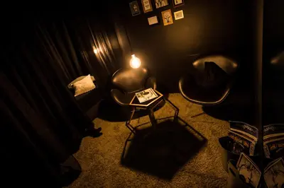 a dark room with two chairs and a table with a light at Design Hotel Tyrol in Rablà