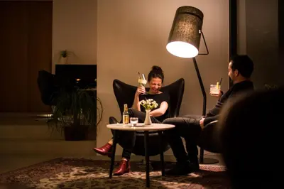 a woman sitting at a table with a glass of wine at Design Hotel Tyrol in Rablà